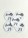 Five round white table place cards with black script reading 'finally 21' arranged on a textured off-white surface.