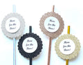 Four glitter paper straws, each with a scalloped circular glitter frame and a white center label reading 'Here for the Boos!'. The toppers come in silver, black, rose gold, and gold colors, arranged on a plain white background.