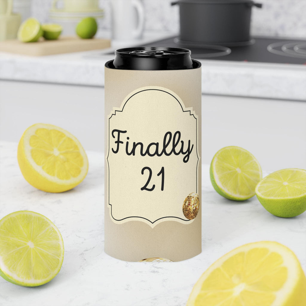 A tall insulated tumbler with a black lid stands on a white countertop in a kitchen setting. The tumbler sleeve is beige with a decorative label that reads 'Finally 21' in black script and numerals, with a small gold glitter accent.