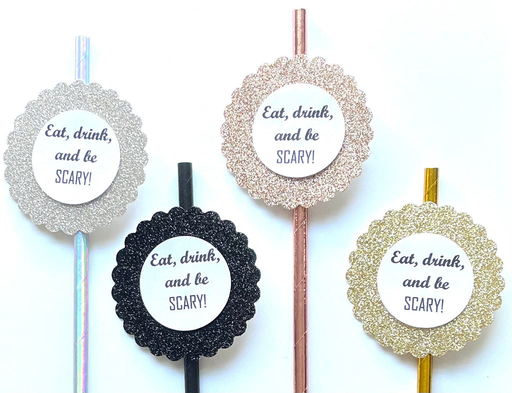 Four round cocktail picks with glittery circular toppers and the printed phrase 'Eat, drink, and be SCARY!' on a white background.