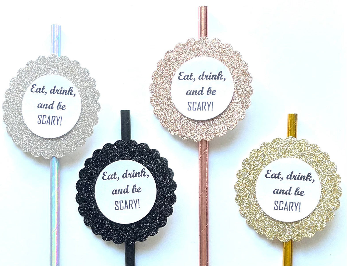 Four round cocktail picks with glittery circular toppers and the printed phrase 'Eat, drink, and be SCARY!' on a white background.