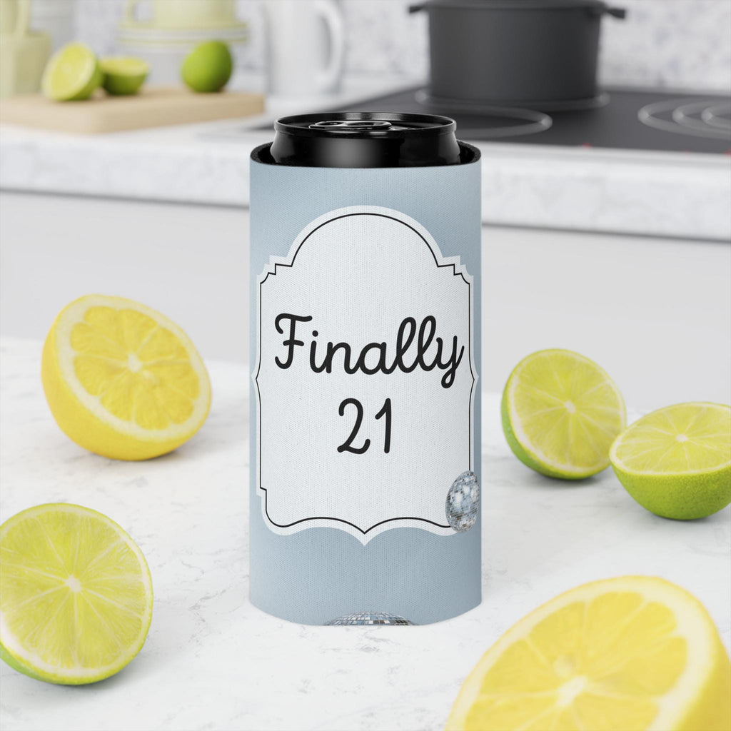 A light blue can cooler sleeve with a white label reading 'Finally 21' in black script, shown around a black can on a kitchen countertop with lemon and lime slices around it.