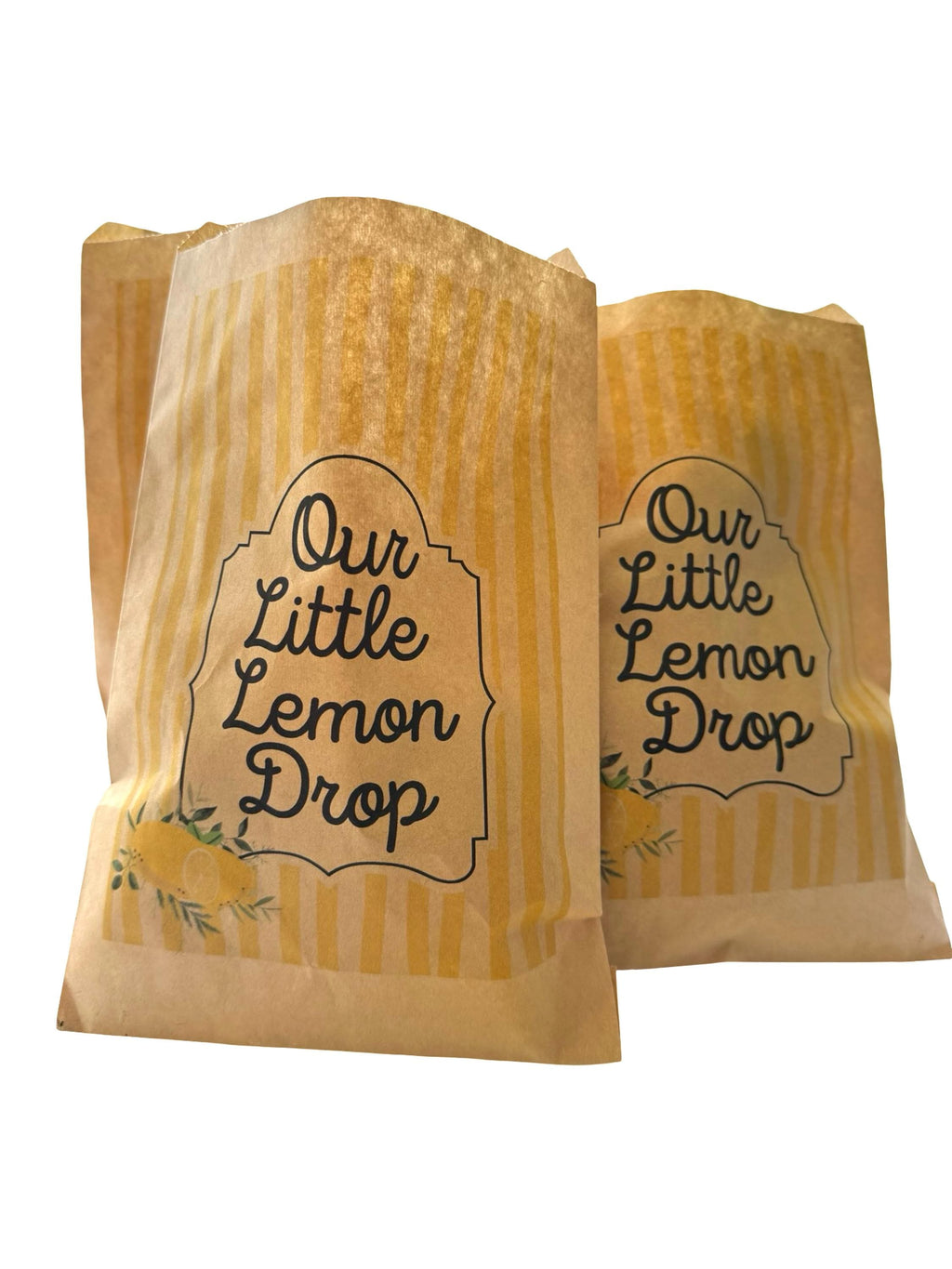 Two yellow and beige striped party favor paper bags with the text 'Our Little Lemon Drop' printed on them, set against a plain white background.