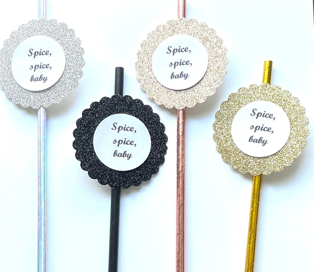 Four decorative straws with round glittery scalloped end pieces and white center labels reading 'Spice, spice, baby' on a white background.